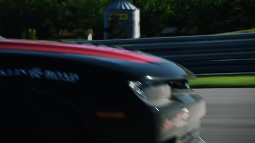 Two race cars racing on an outdoor track