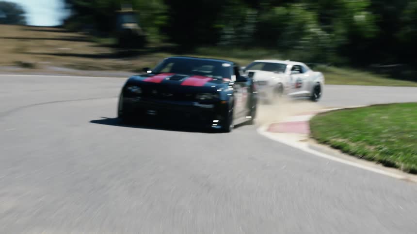 Cars are driving on a race track during the spring time