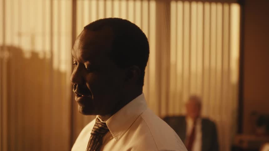 Men are sitting in an office while the sun is setting