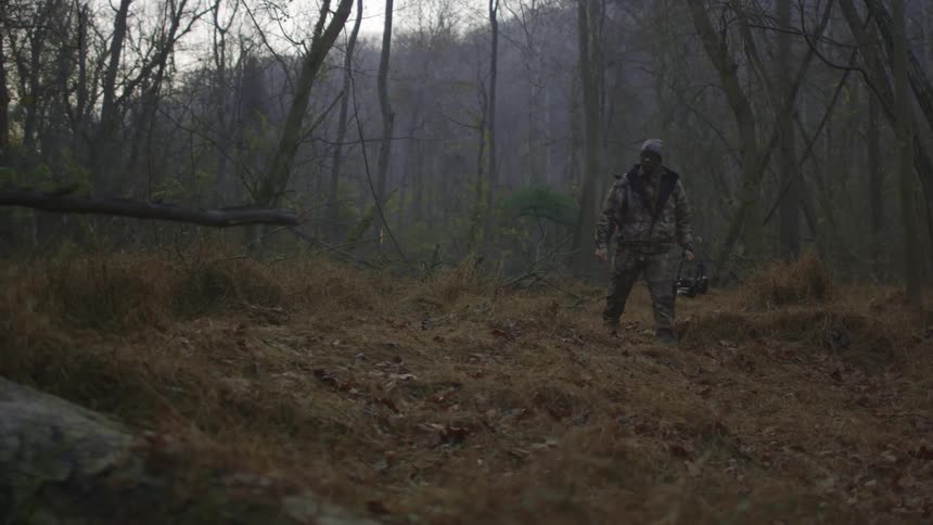 A man walks in some dead grass