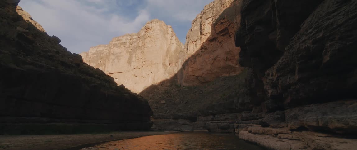 A stream running along the floor of a canyon during the day