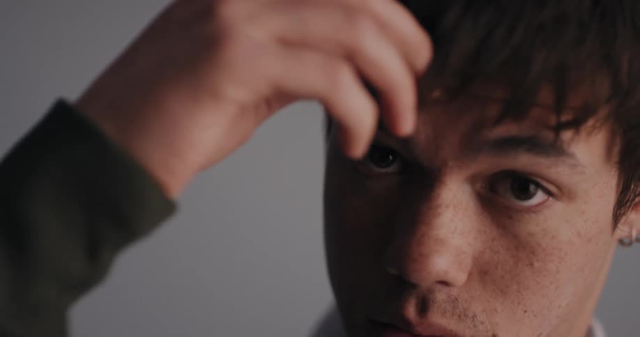 Handsome young man fixing his hair with his hand