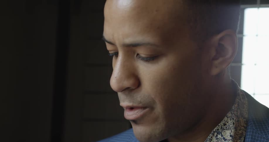 A man in a blue jacket licks his lips