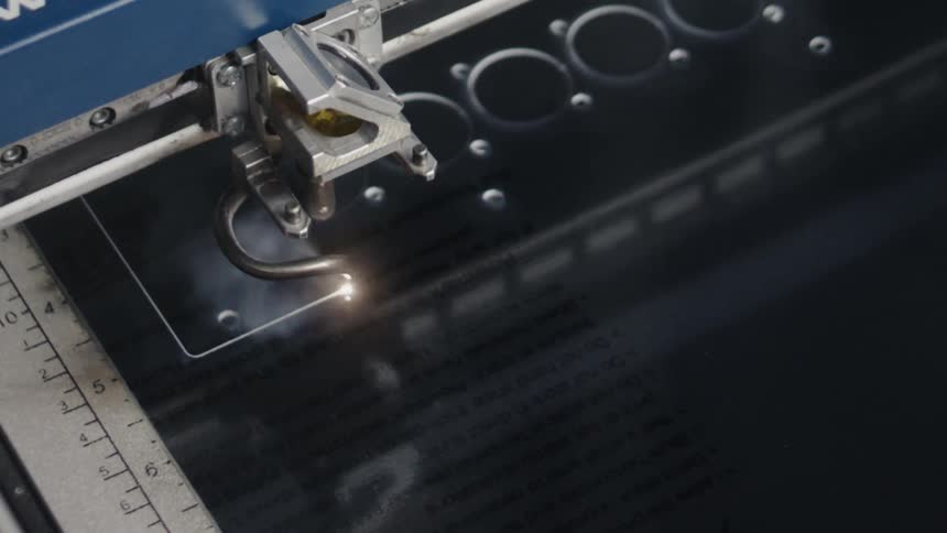 A flame ignites as a laser machine etches an object