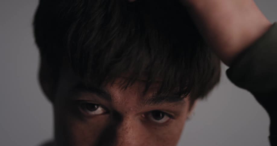 Handsome young man fixing his hair with his hands and moving his head around