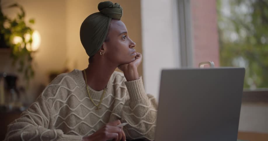 A woman is sitting at her desk by her computer