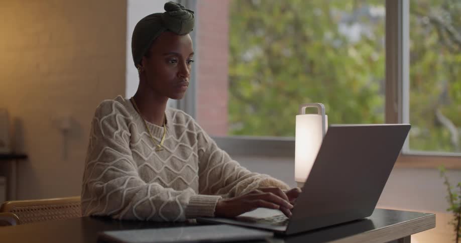 Young woman sitting at a desk at home working on a laptop