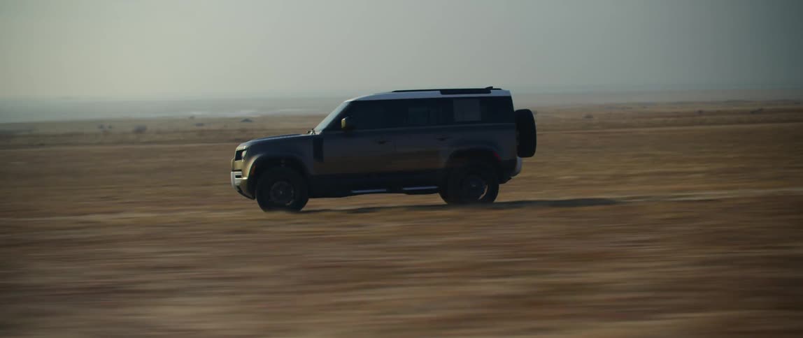 An suv speeds along an asphalt road in a desert region and quickly turns off onto a dirt path and continues speeding