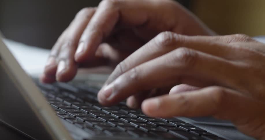 A person types on a laptop