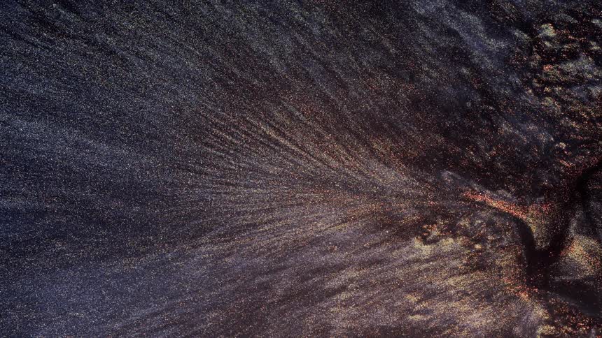 Purplish mixture with silvery particles floating in it flows into crevice
