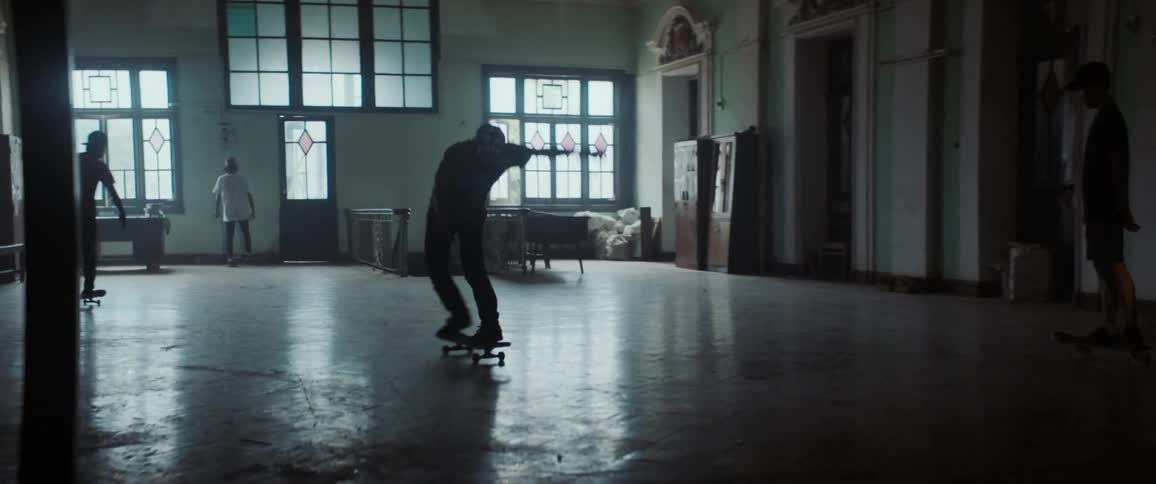 A group of people are skateboarding in an indoor room