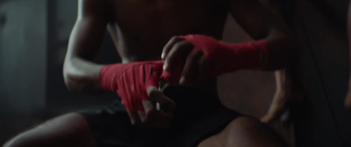 Man sits in gym wrapping his hands