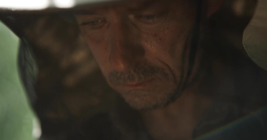 A man is standing outdoors and wearing a hat