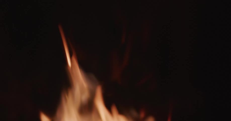 A bonfire is lit outdoors at night time