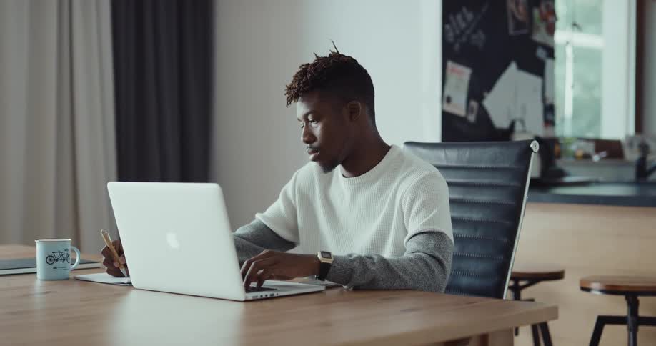 A man sitting in a room using a laptop