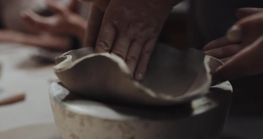 People are making a bowl with clay