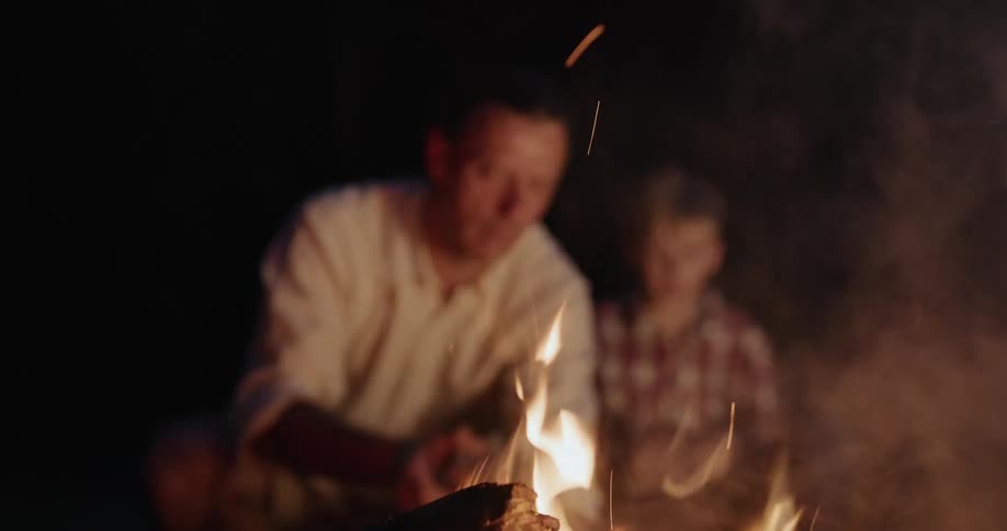 A man stirs the campfire