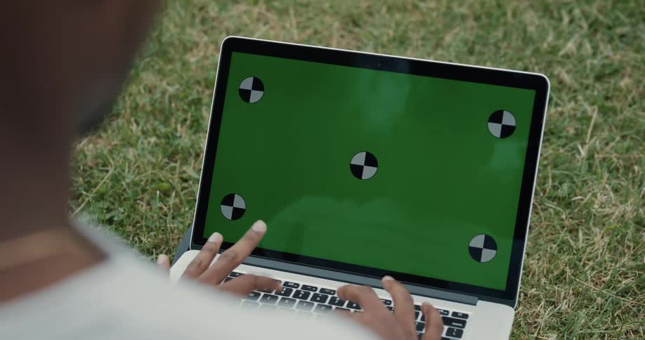 Person sits outside typing on laptop