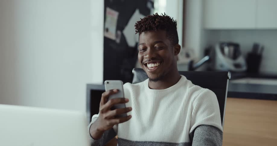 A man using a laptop and smartphone