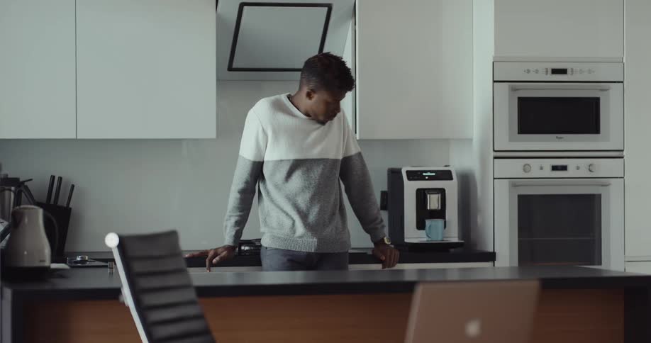 A man is waiting for his coffee to be done brewing