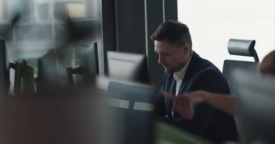 A man is sitting at his computer desk while at work