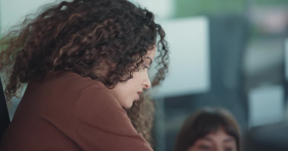 Businesswomen work at the office holding documents and talking to each other