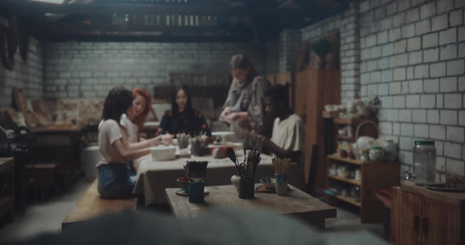 A group of people are shaping dough at a table