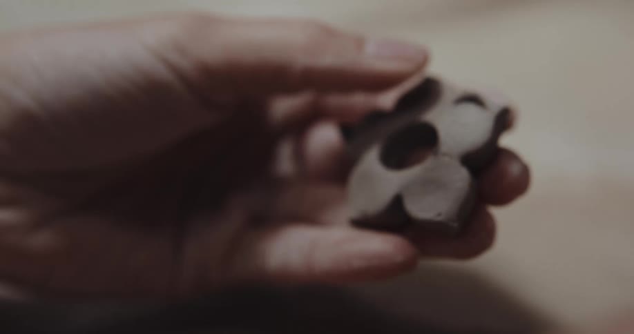 Person uses cookie mold to shape clay