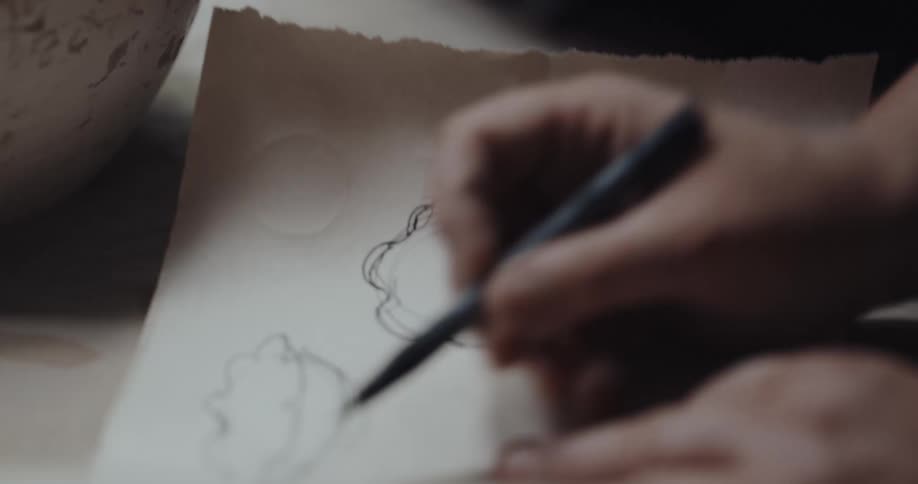 A person is sketching on a piece of paper