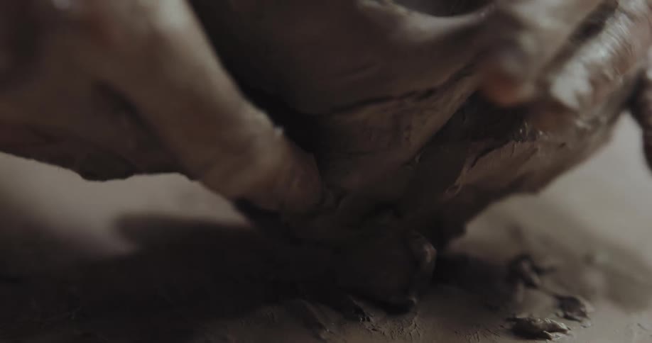 A person is pressing clay with his hands