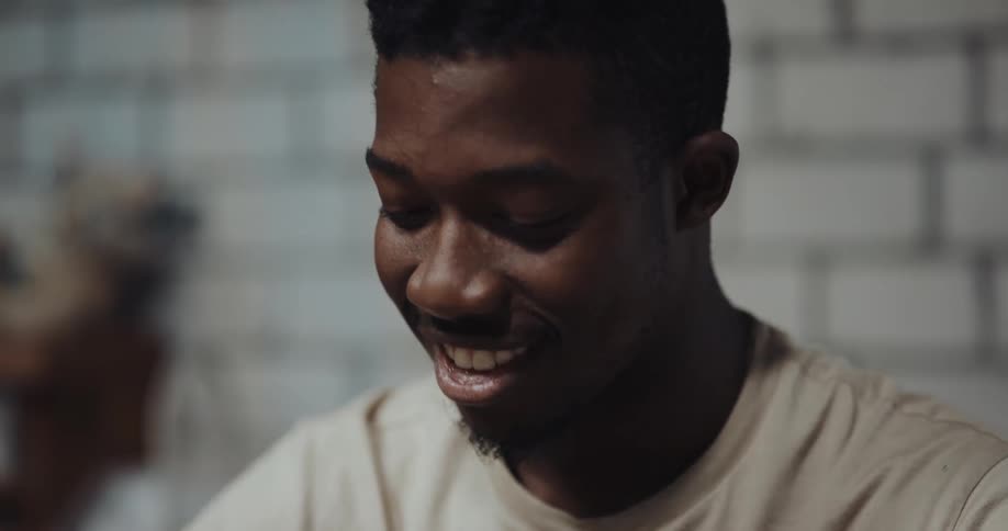 A man is sitting in a room and smiling