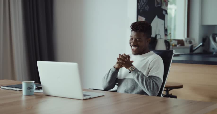 A man claps while using his laptop