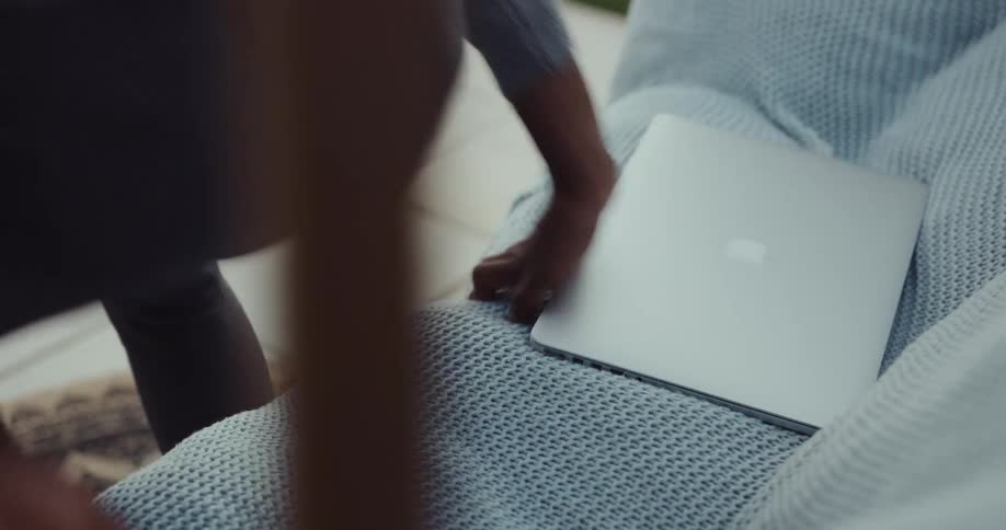 A man is sitting down typing on a laptop computer then he closes the lid and sets the computer next to him and gets up and walks away