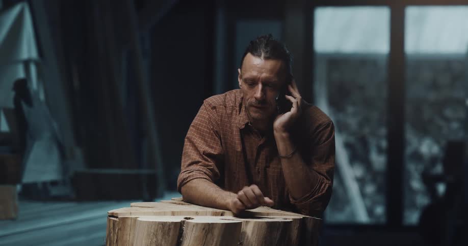 A man is talking on his cellphone and standing in his house