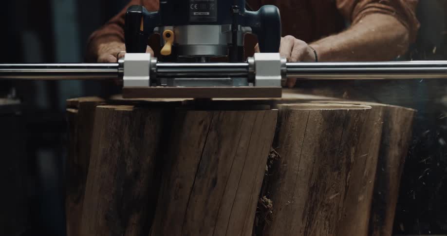 A man is using a machine to cut bark on a tree