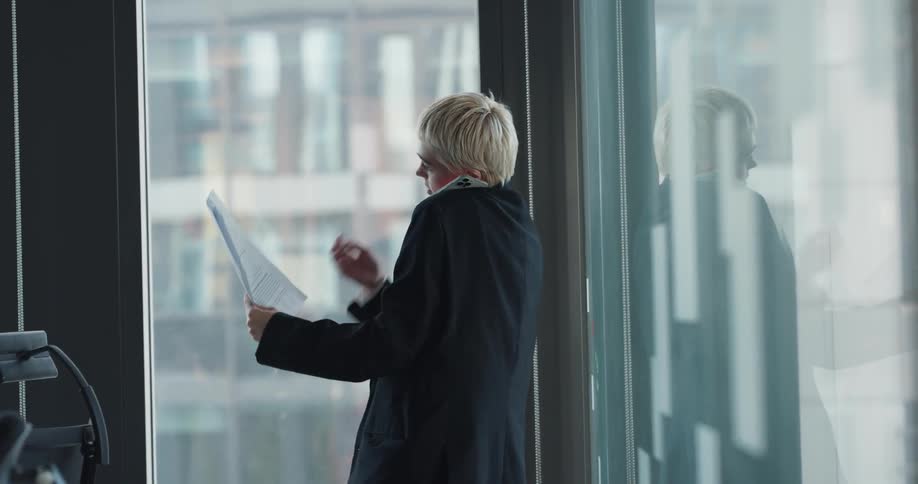 A woman is talking on a cellphone in her office