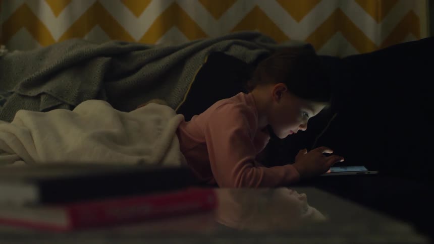A girl is in bed using a tablet
