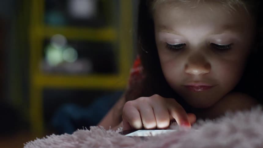 A girl plays on a tablet