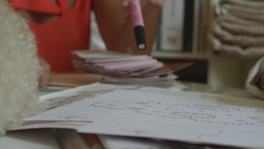 A person taps a marker on some papers