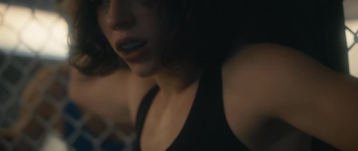 Young tired female cage fighter stands up ready to fight on the ring