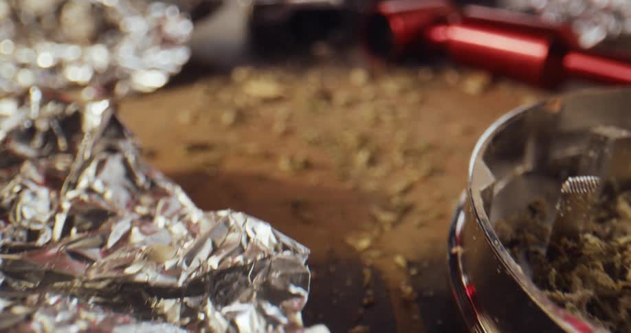 Drugs and accessories are strewn on a table with some of it spilled