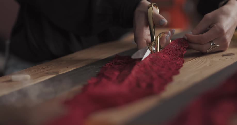 A person cuts red fabric