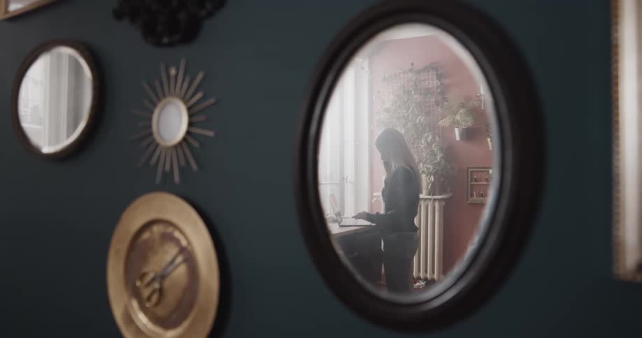 A woman is walking around her house during midday