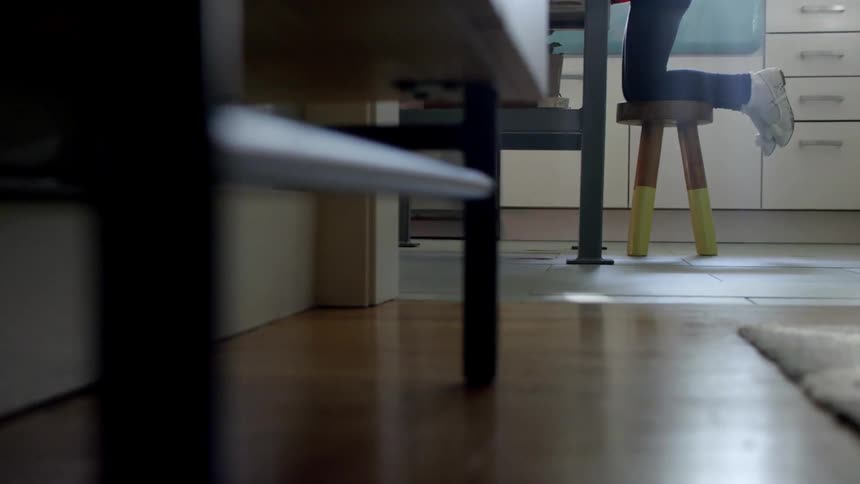 A person kneels on a stool