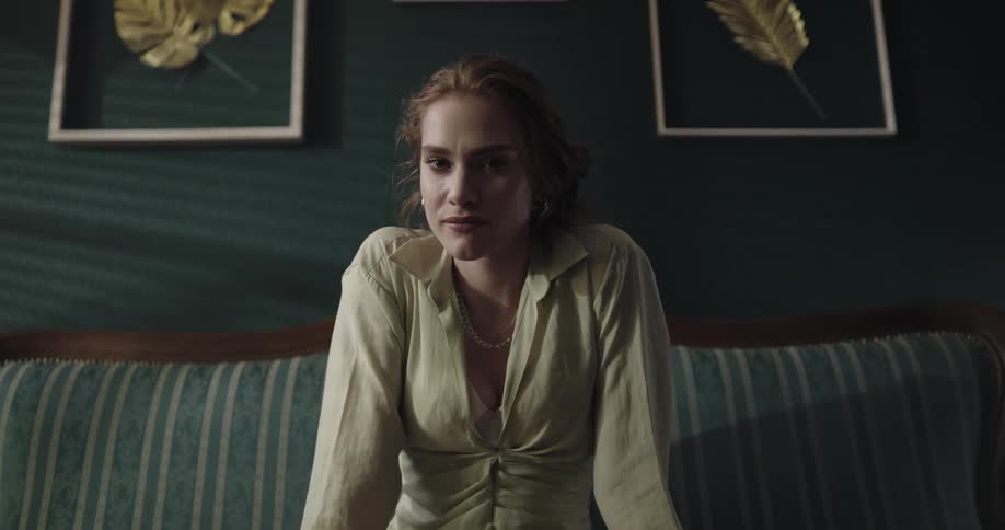 A woman is smiling and sitting on a couch