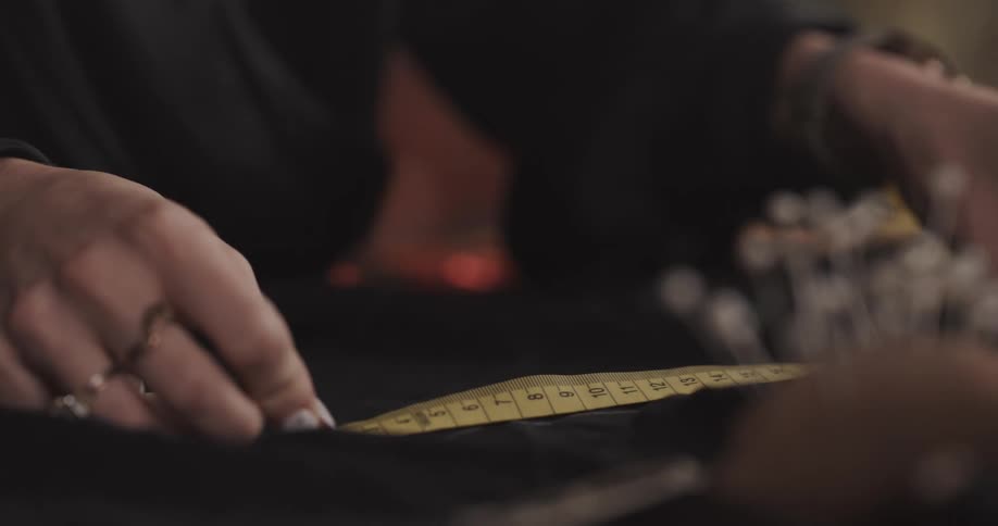 A person uses a measuring tape to measure a piece of fabric
