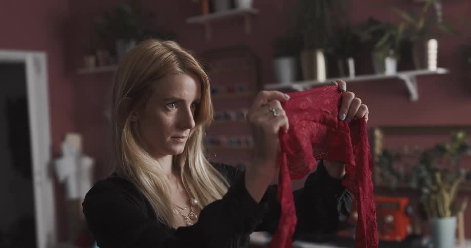 Female tailor inspecting a piece of fabric inside her workshop