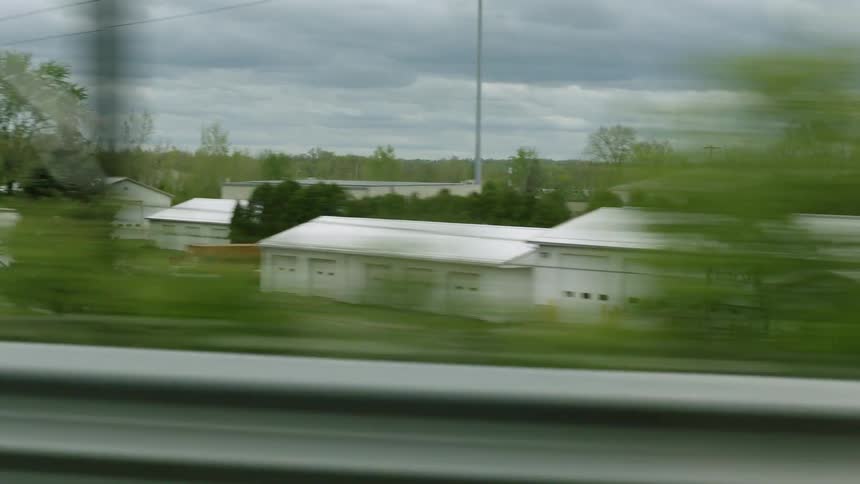 Houses in the neighborhood of a small town seen from a moving car on the highway