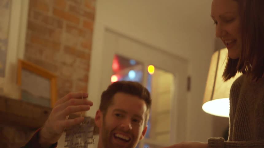 A man and woman look at christmas ornaments