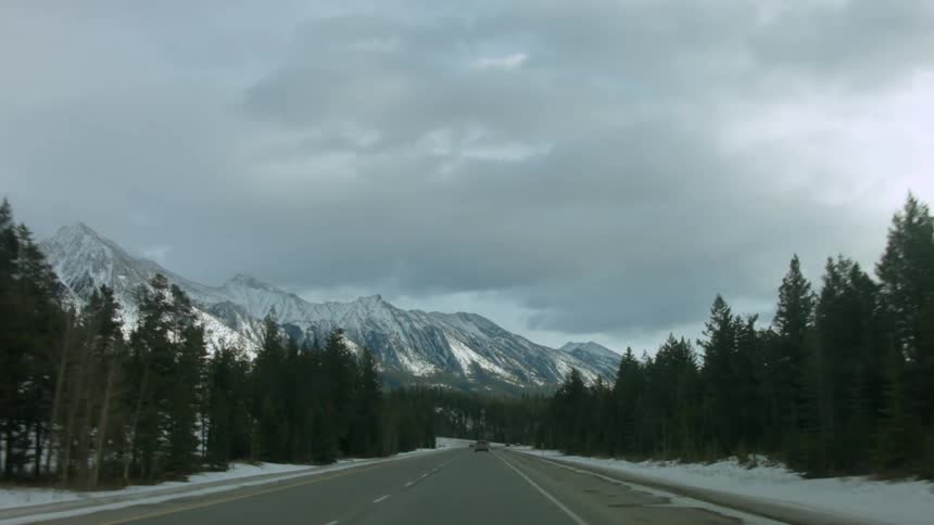 Driving down a winter road toward the mountains